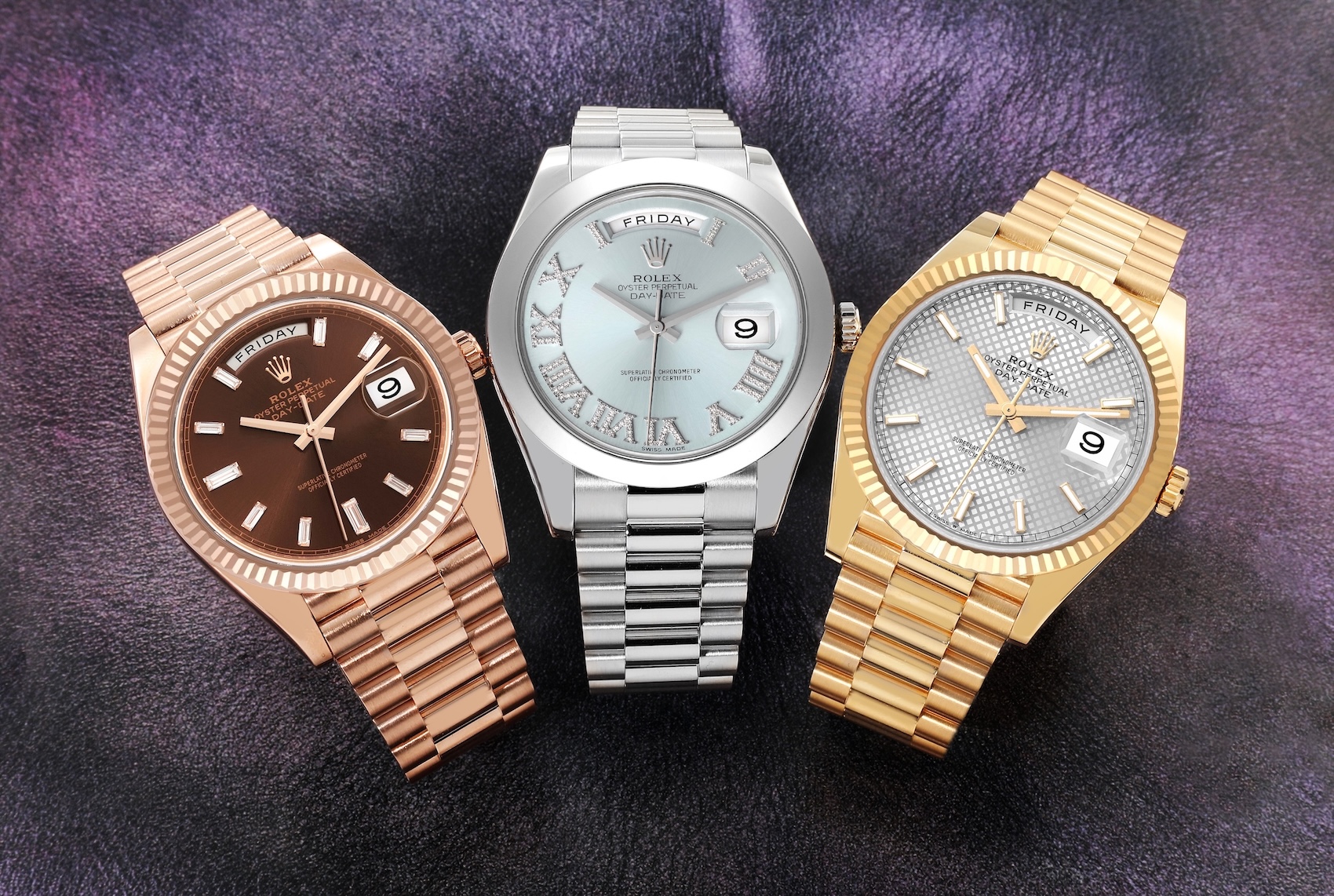 Three Rolex Day-Date 40 watches, known as the President, shown side-by-side in 18k Everose gold, 950 platinum, and 18k yellow gold, all featuring the iconic President bracelet.