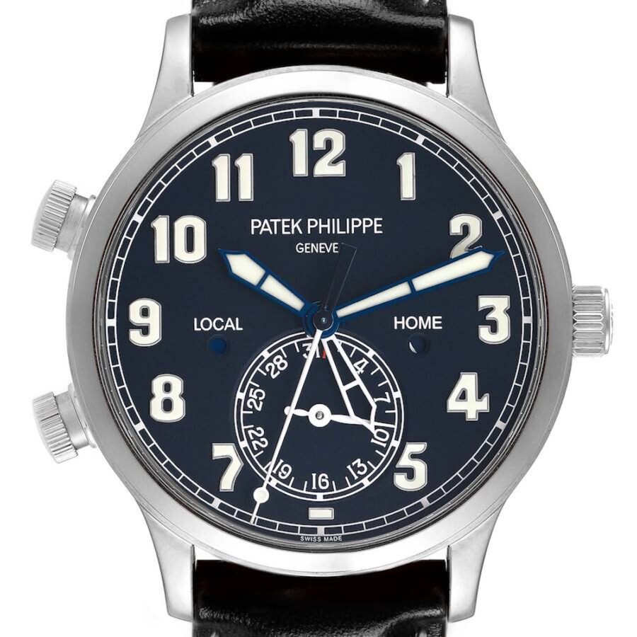 A clear dial shot of the Patek Philippe 5524G Calatrava Pilot, showing the skeletonized 'Local' time hand, solid 'Home' time hand, and date sub-dial at 6 o'clock.