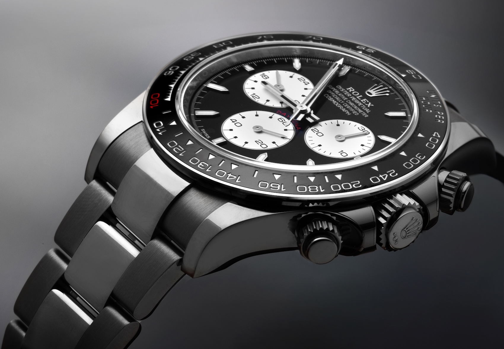 Angled view of the Rolex Daytona Le Mans white gold watch, highlighting the black Cerachrom bezel with the red '100' marker.