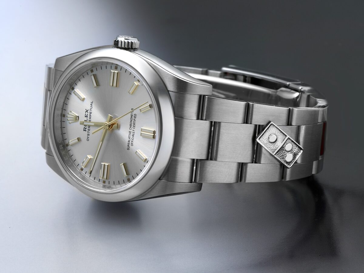 Side profile of Rolex Oyster Perpetual bracelet showing the custom steel Domino's Pizza link attachment.