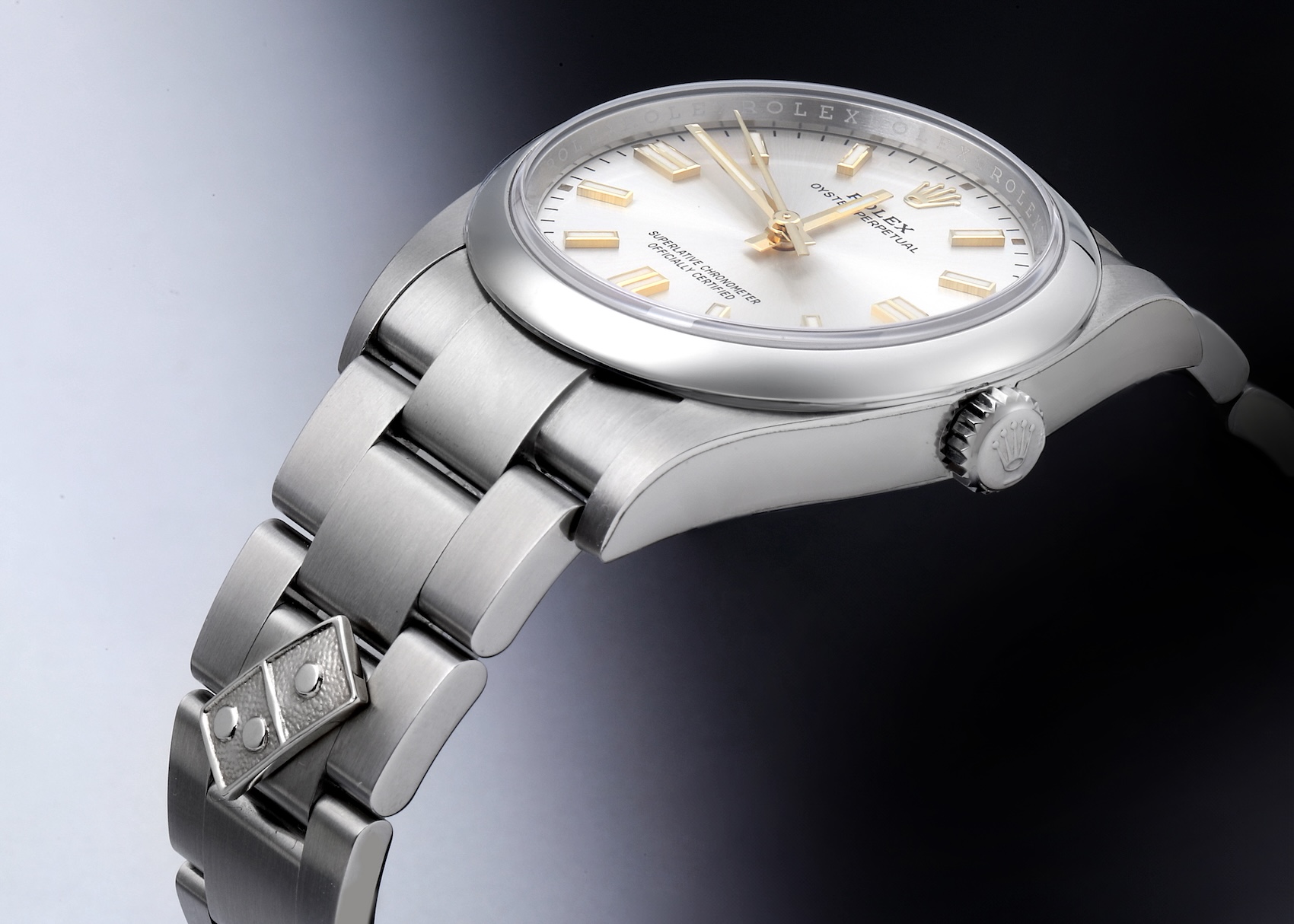 Close-up of the riveted Domino's logo on the bracelet of a Rolex Oyster Perpetual Ref. 126000.