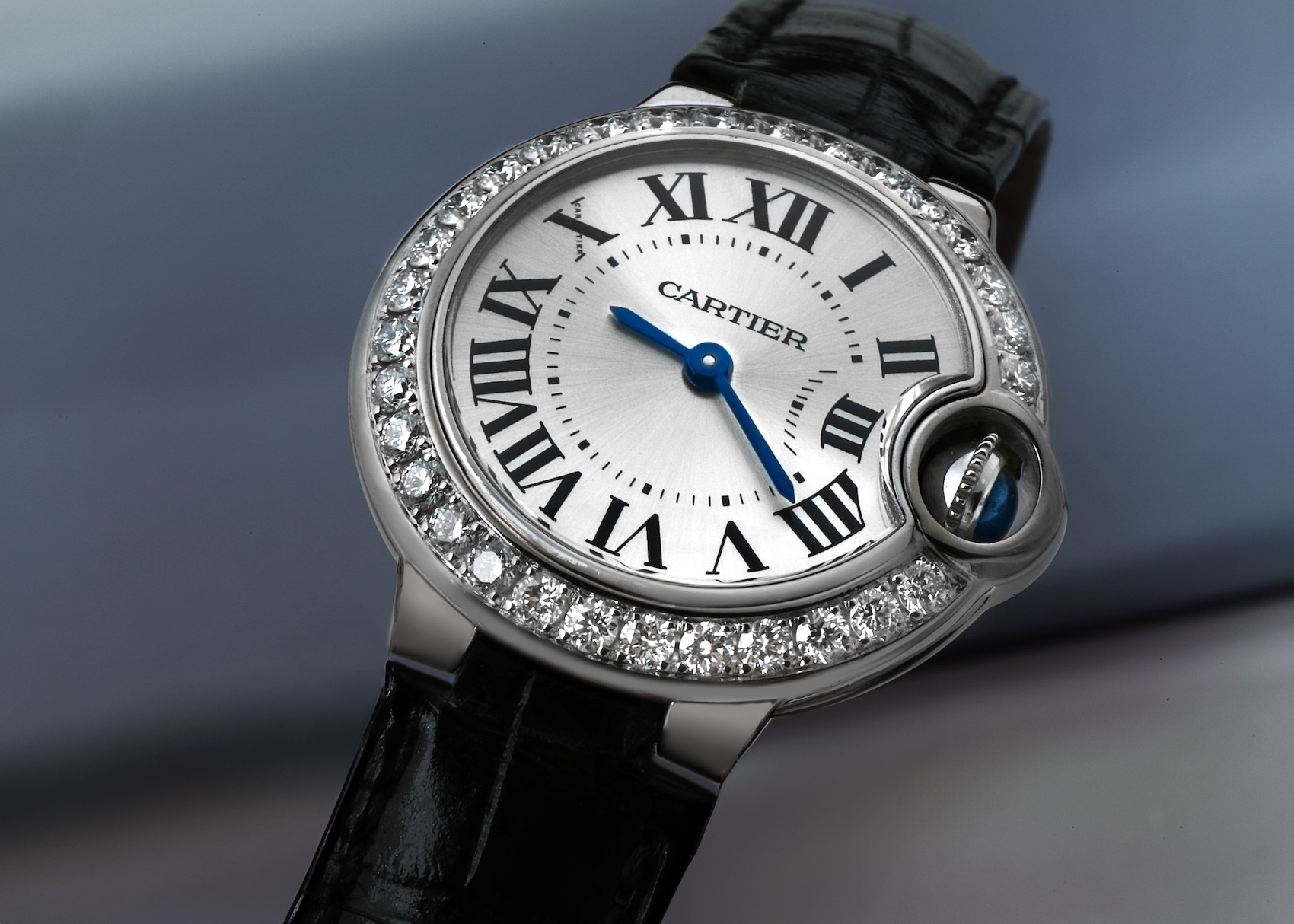 Close-up of a Cartier Ballon Bleu 28mm ladies watch (Ref WE900351) featuring a white gold case, diamond bezel, and silver dial.