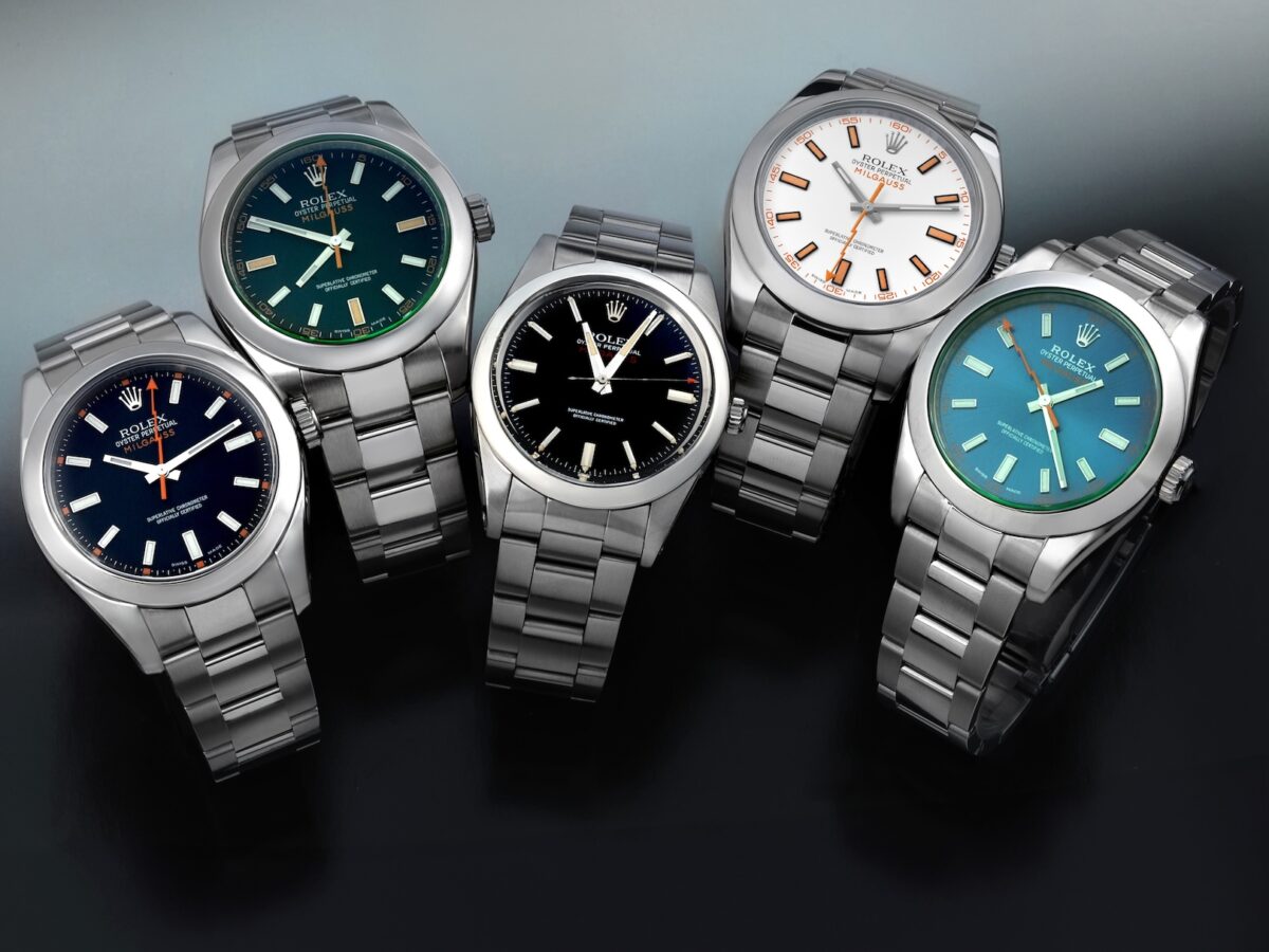 A collection of five Rolex Milgauss models including the vintage ref 1019, modern 116400 white and black dials, and 116400GV Z-Blue and black dials.