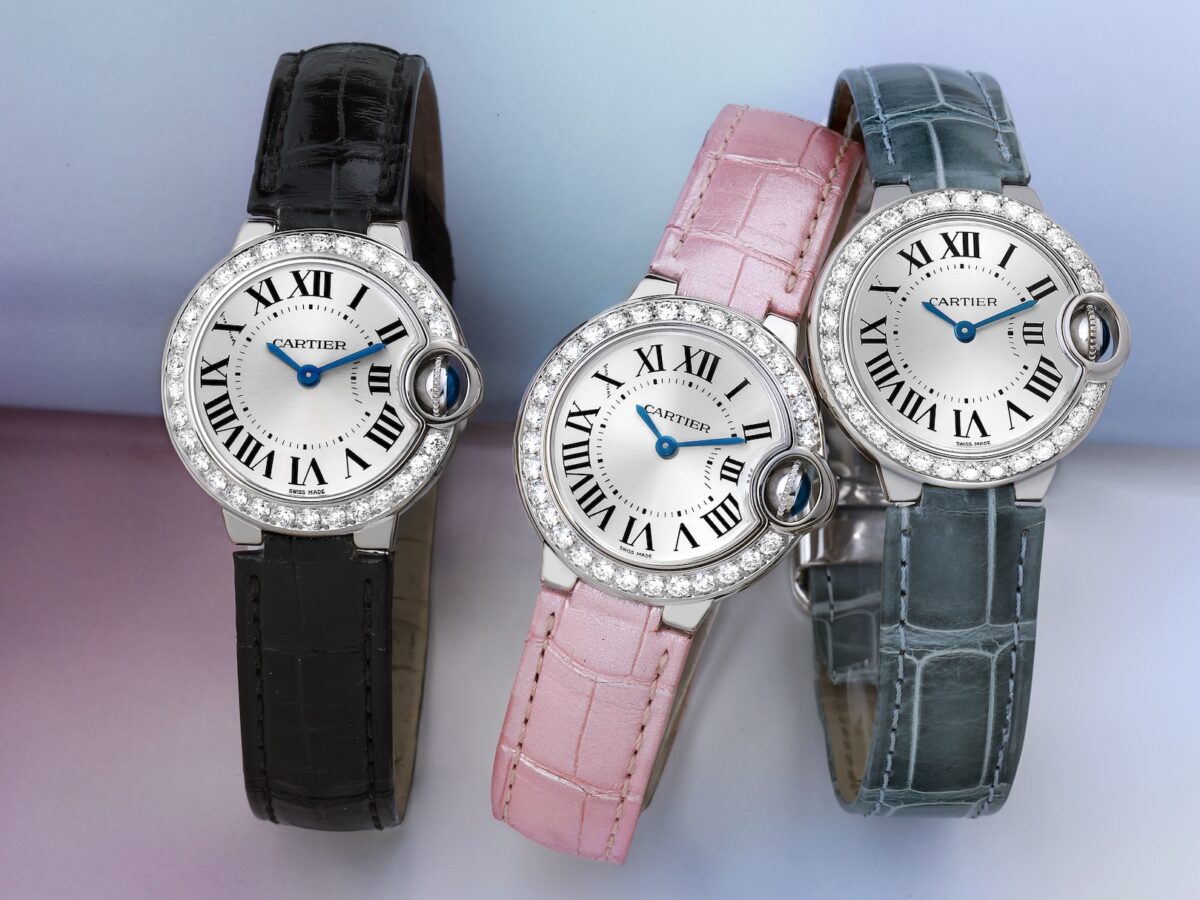 Three Cartier Ballon Bleu 28mm white gold watches with diamond bezels, shown with black, pink, and grey leather straps.