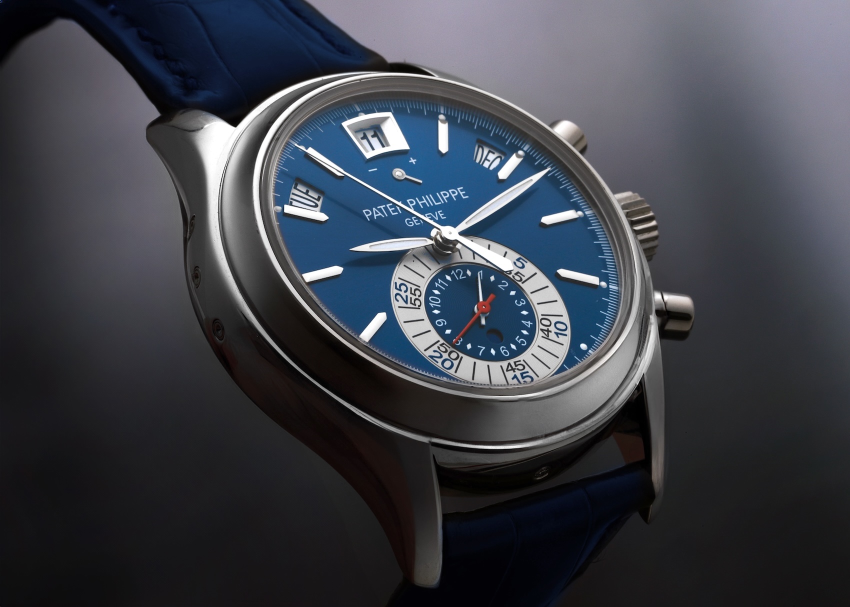 Angled close-up of the Patek Philippe Ref. 5960P-015 in platinum. The watch features a sunburst blue dial, white gold applied hour markers, and a mono-counter at 6 o'clock containing the chronograph minute and hour totalizers. The case is fitted with a blue alligator leather strap.