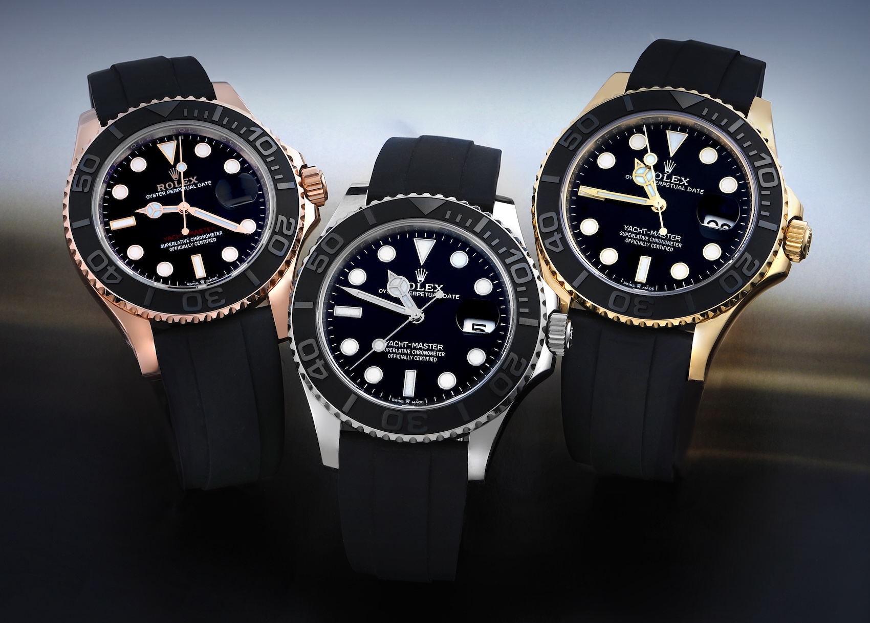A group shot of the Rolex Yacht-Master Oysterflex lineup in Everose, White, and Yellow gold, angled to show the polished finishes and dial details.