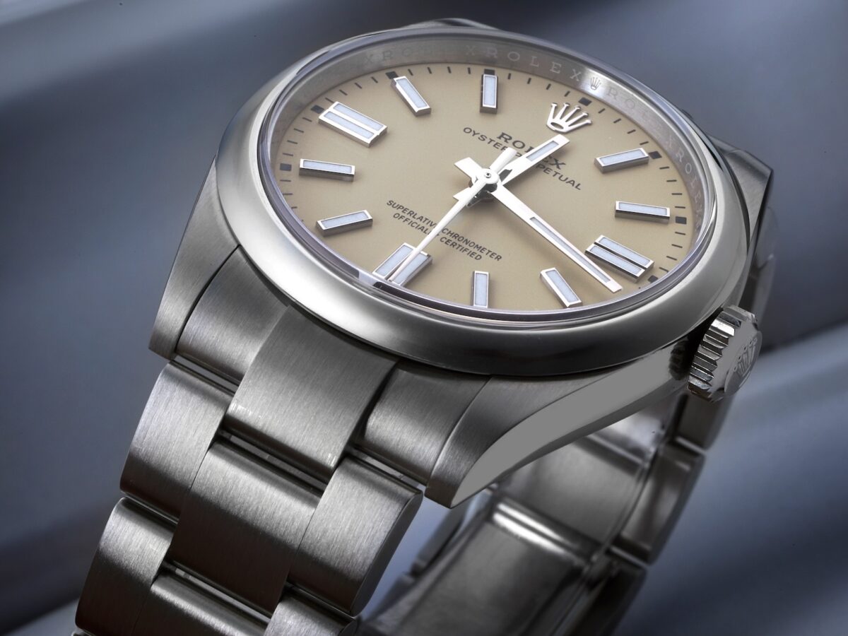 Angled view of the 41mm Rolex Oyster Perpetual on an Oystersteel bracelet, highlighting the warm matte beige dial and polished bezel.