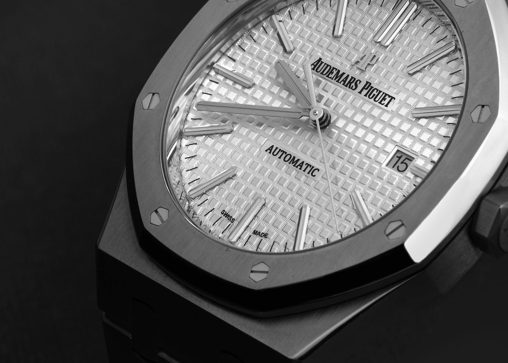 Extreme close-up of an Audemars Piguet Royal Oak silver dial featuring the signature "Grande Tapisserie" pattern and octagonal bezel with exposed hexagonal screws.