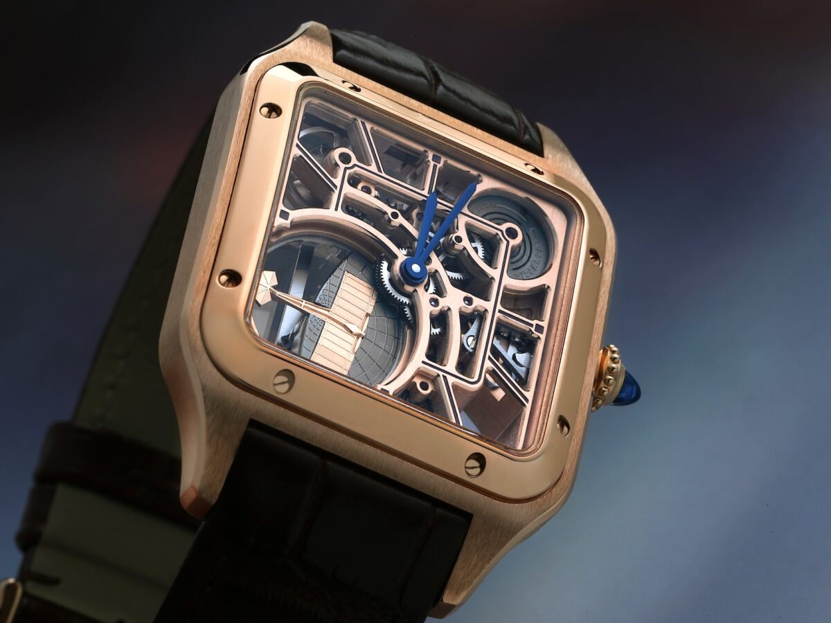 A close-up, angled view of the rose gold Cartier Santos-Dumont Micro-Rotor Skeleton watch, highlighting the blue steel hands and the intricate aviation-inspired micro-rotor.