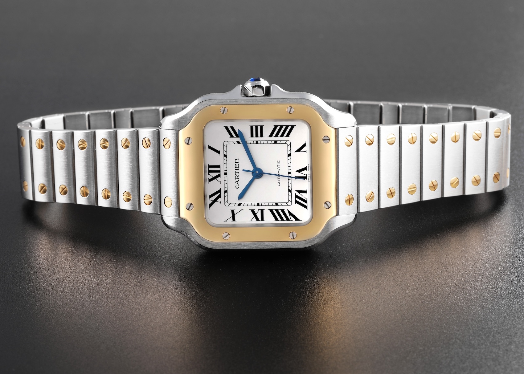 A Cartier Santos Medium model in two-tone steel and yellow gold, featuring its signature square case and Roman numeral dial.