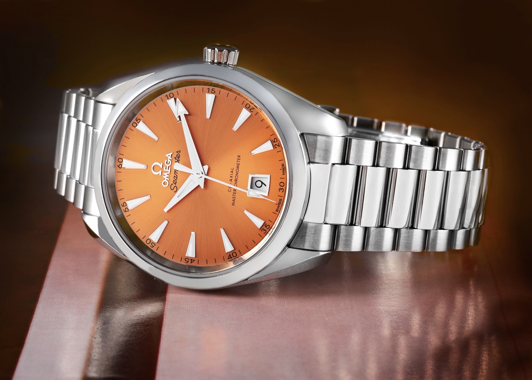 An Omega Seamaster Aqua Terra Shades watch with a polished steel case and a sun-brushed saffron orange dial.