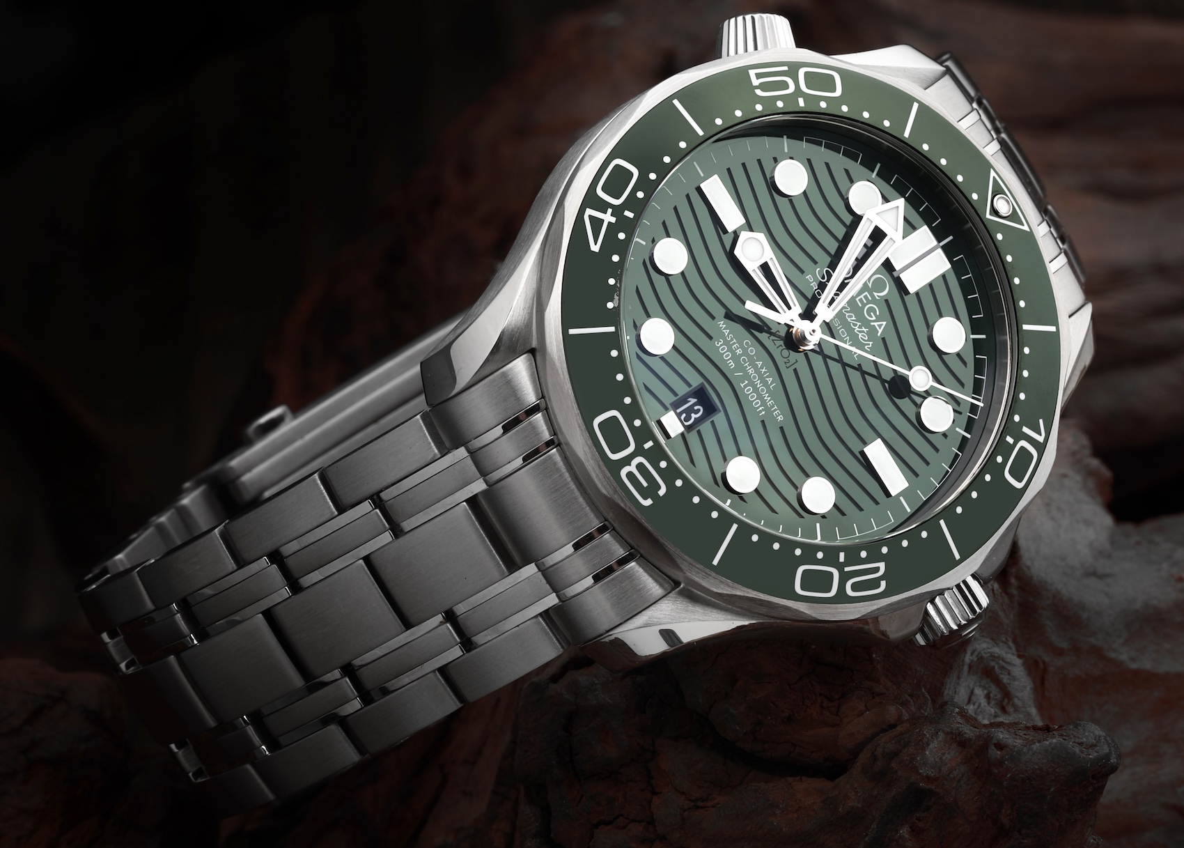 Omega Seamaster Diver 300M 210.30.42.20.10.001 with green wave dial and green ceramic bezel on a steel bracelet.