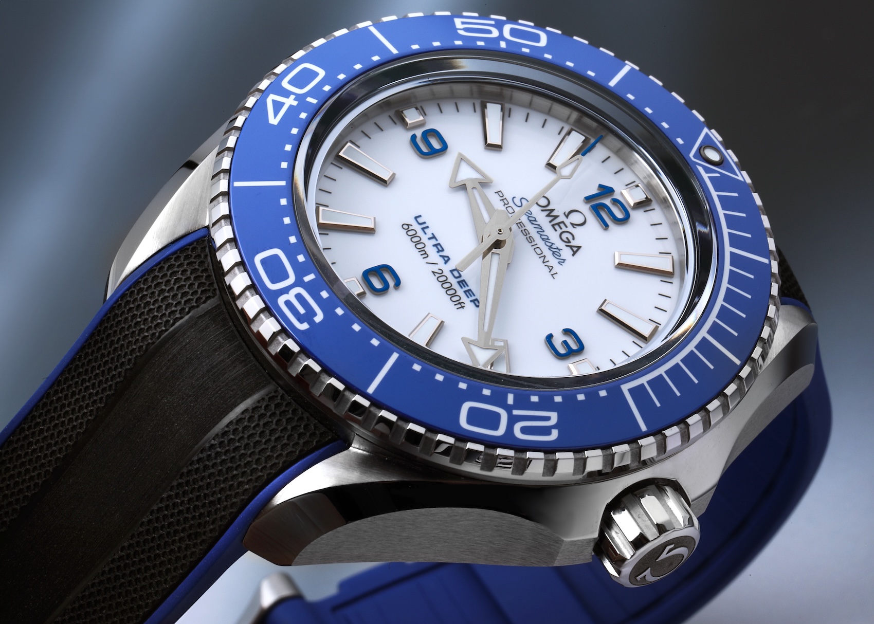 Omega Seamaster Planet Ocean Ultra Deep 215.32.46.21.04.001 with white dial and blue bezel on a rubber strap.