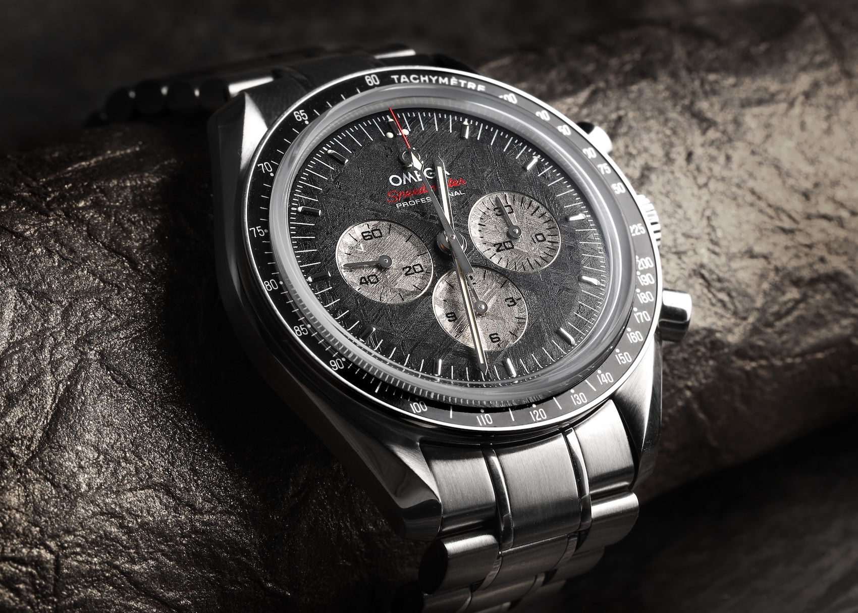  Detailed macro shot of an Omega Speedmaster with a meteorite dial, showing the intricate, crisscrossing Widmanstätten patterns in the chronograph registers.