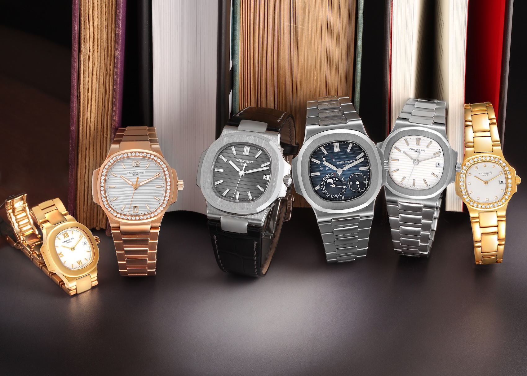 An assortment of Patek Philippe Nautilus watches including rose gold diamond-set, stainless steel moonphase, and yellow gold ladies' models.