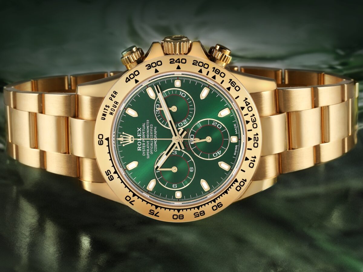 A front-facing "hero shot" of the Rolex Cosmograph Daytona Ref. 116508 with its signature bright green dial, red sub-dial accents, and yellow gold Oyster bracelet.