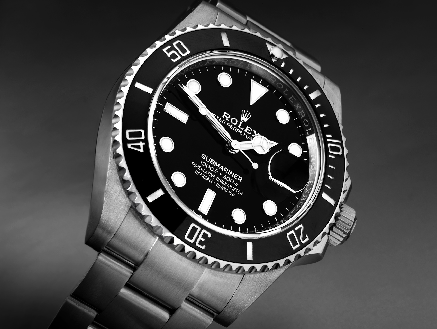 A high-contrast, professional studio shot of the Rolex Submariner 126610LN, highlighting the "Submariner" text and the Cyclops lens over the date window.