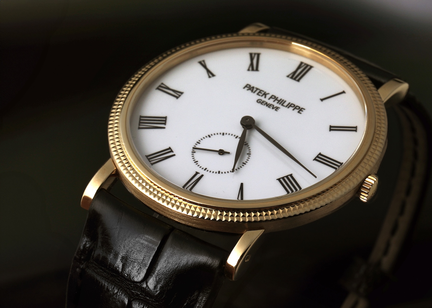 A Patek Philippe Reference 5119J in yellow gold shown from a side profile, highlighting the small seconds sub-dial at 6 o'clock and the sharp, pyramid-like texture of the hobnail bezel.