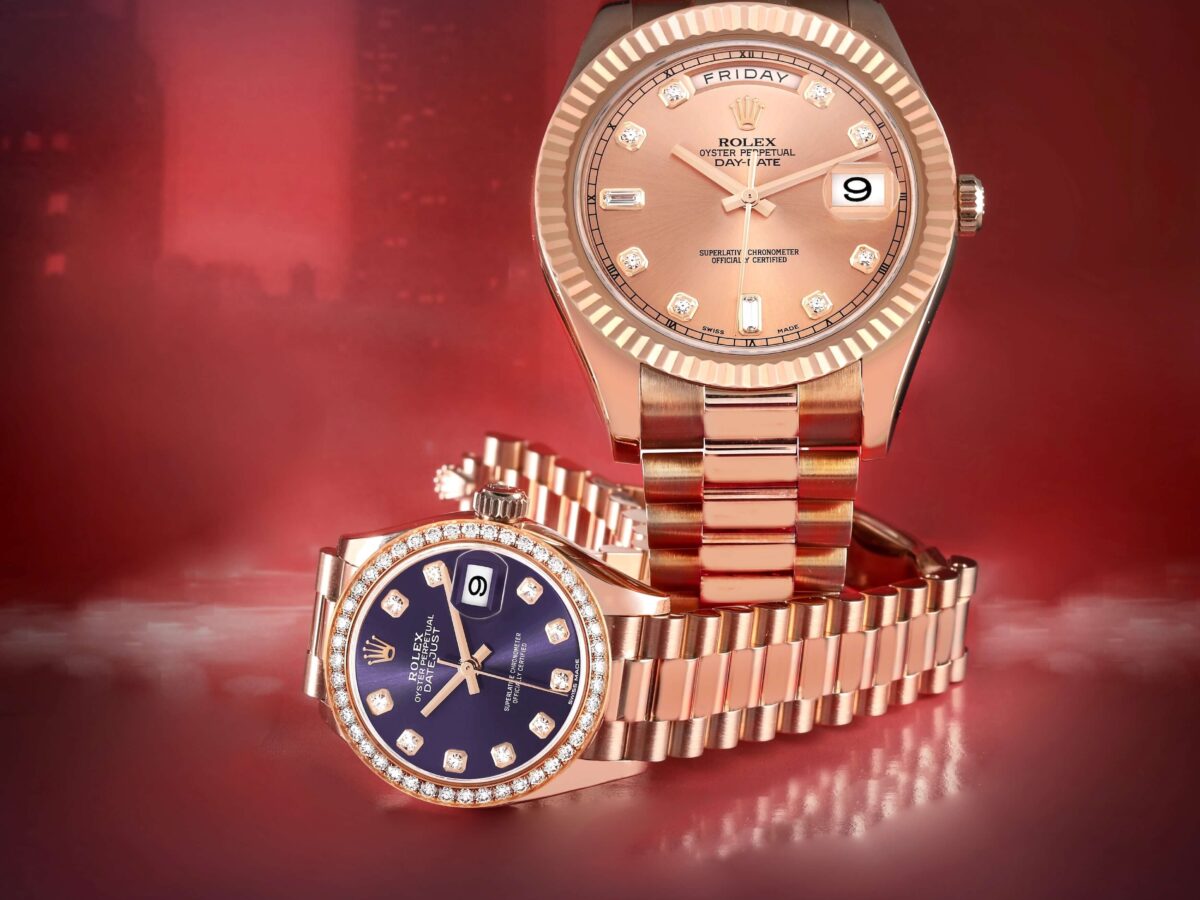His and hers Rolex President watches in 18k Everose gold, featuring a Day-Date 40 and a ladies' Datejust with a diamond bezel and purple dial on a red background.