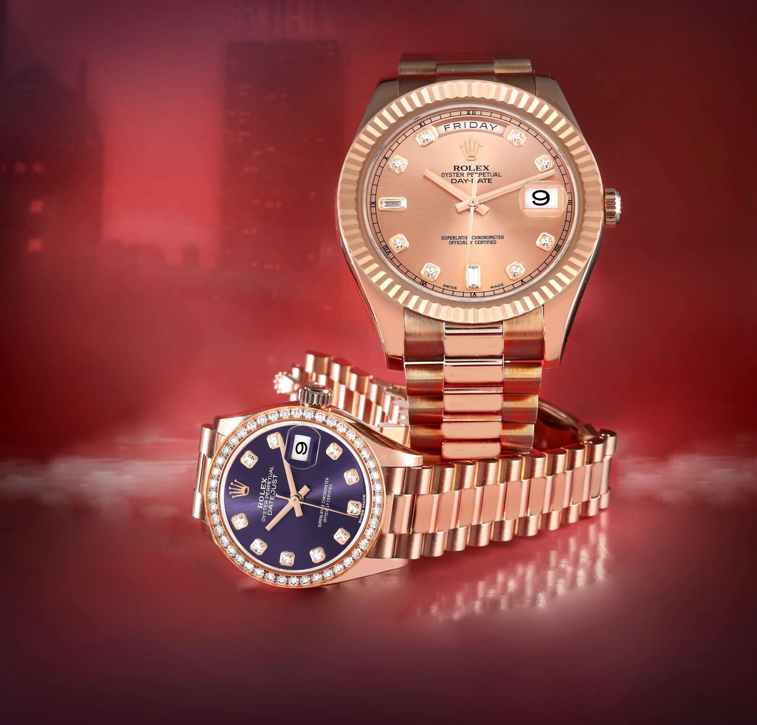 His and hers Rolex President watches in 18k Everose gold, featuring a Day-Date 40 and a ladies' Datejust with a diamond bezel and purple dial on a red background.
