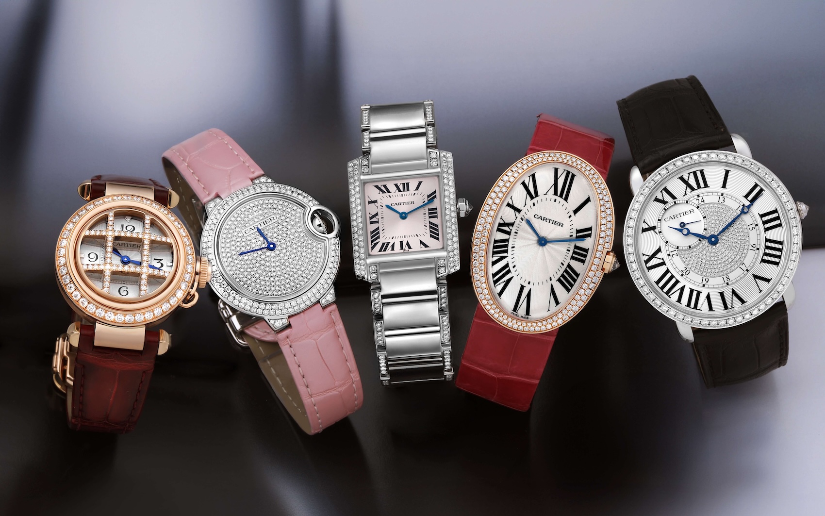 A colorful collection of Cartier watches including the Tank, Baignoire, and Pasha, highlighting the brand's mastery of shaped cases.