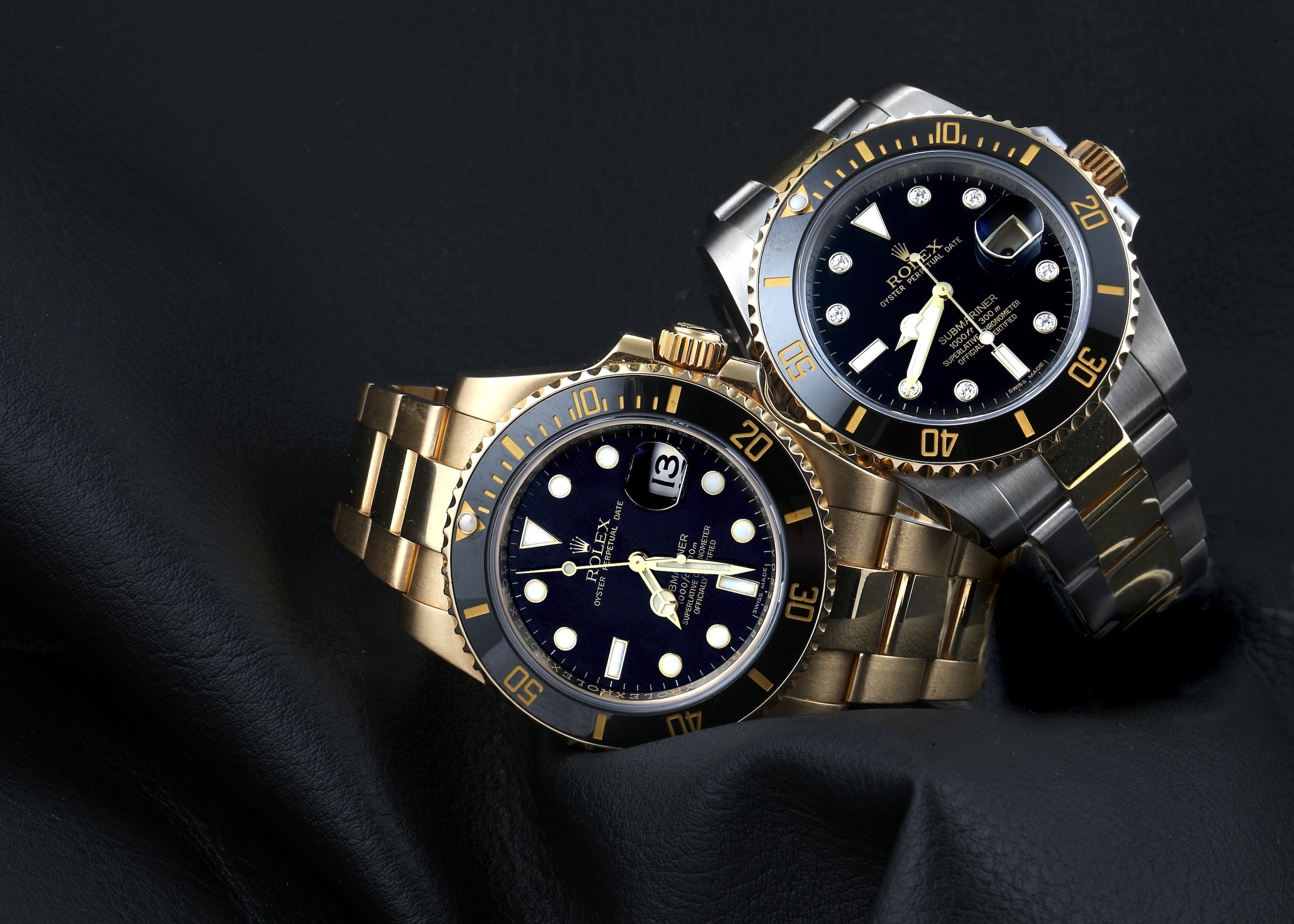 Two Rolex Submariner Date watches demonstrating the genuine 2.5x date magnification under the Cyclops lens.