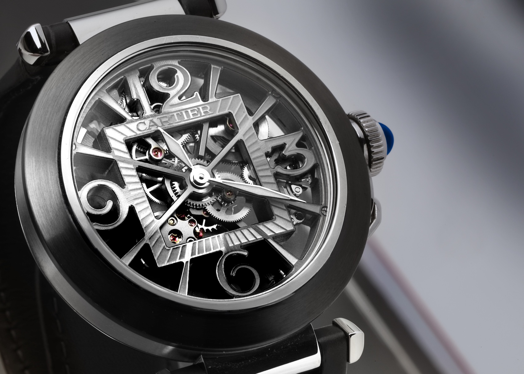 Macro photography of a skeletonized Cartier Pasha watch movement where the bridges form the dial's numerals.