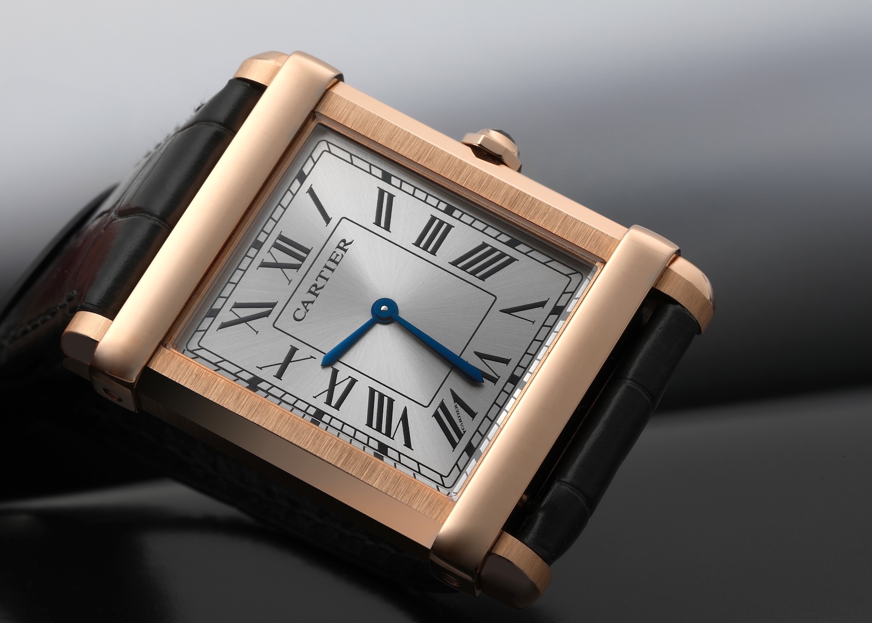 Cartier Tank Chinoise rose gold men's watch with a gray sunburst dial and classic Roman numerals.