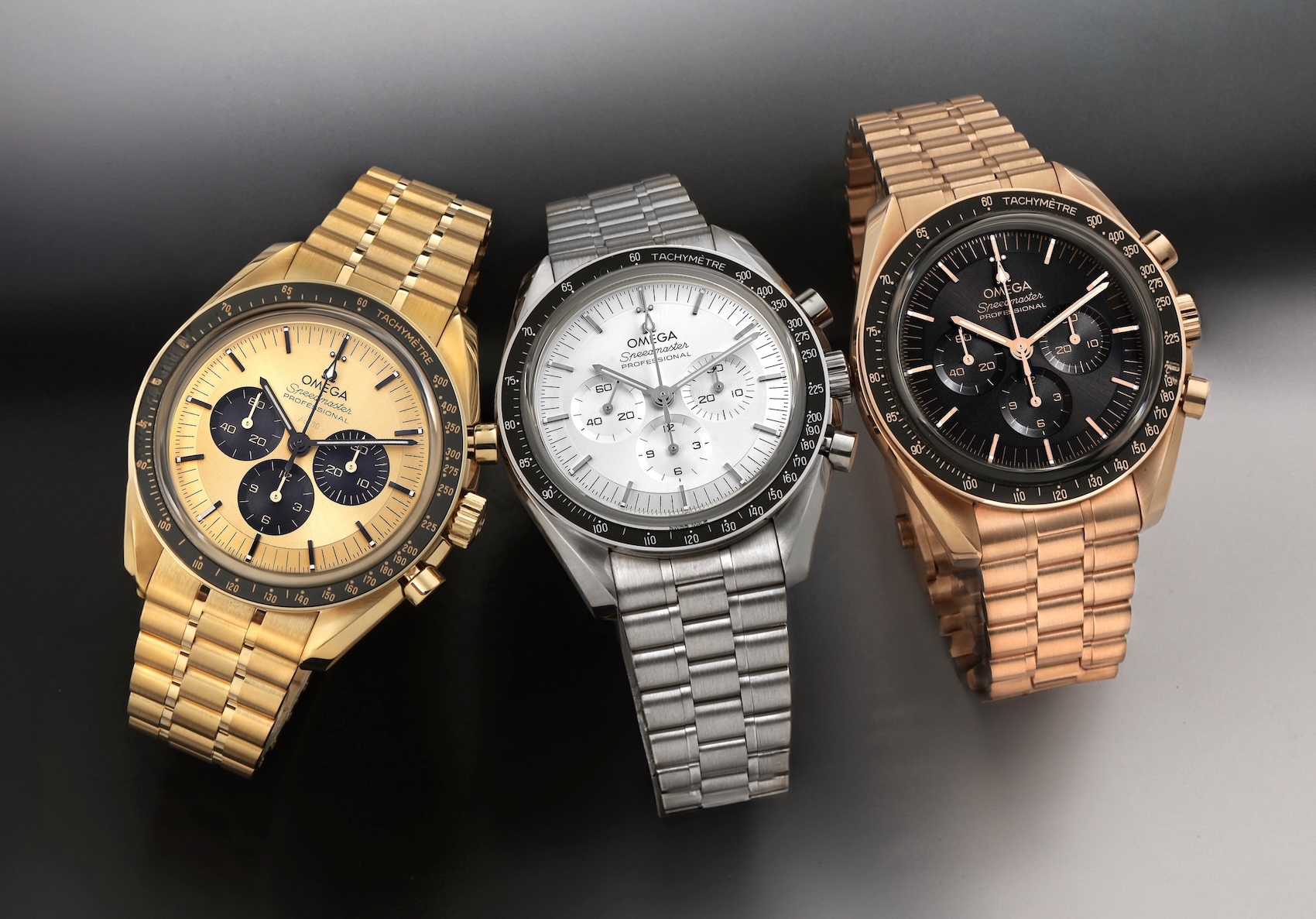 A horizontal comparison view of three Omega Speedmaster Professional watches. The left is made from pale yellow 18K Moonshine Gold, the middle is from silvery 18K Canopus Gold, and the right is from warm rose 18K Sedna Gold, all with distinct bracelets and dials.