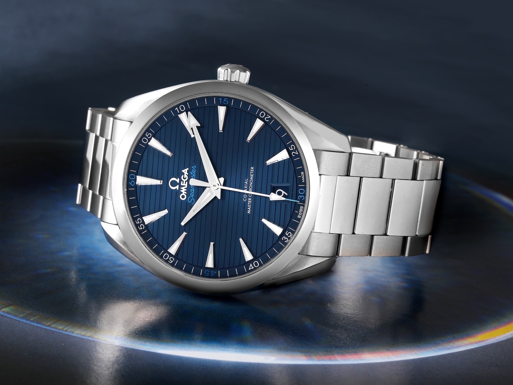 Omega Seamaster Aqua Terra 41mm with blue teak dial resting on a reflective surface