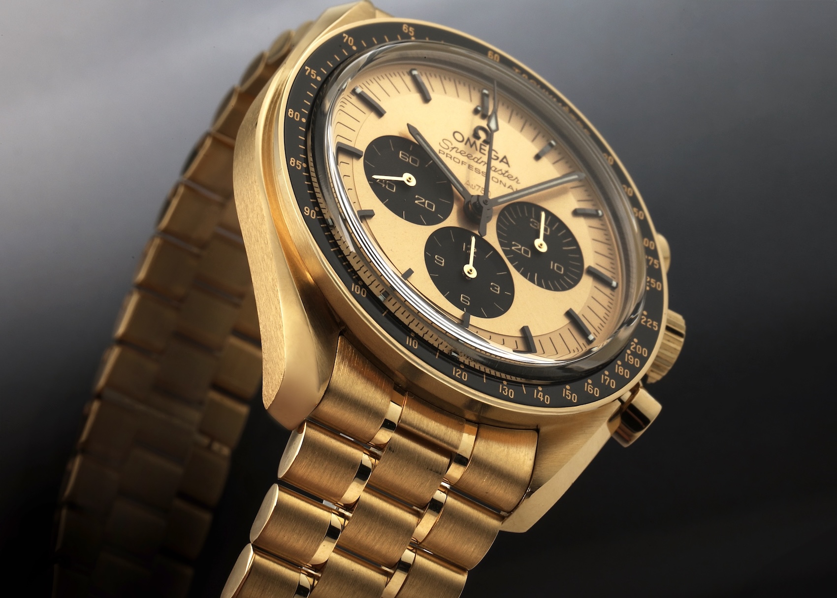 An all-gold Omega Speedmaster Professional watch, crafted from the pale 18K Moonshine Gold alloy. The case, matching integrated bracelet, and pale yellow dial are all the distinct soft color of Moonshine Gold, with a black tachymeter bezel. 