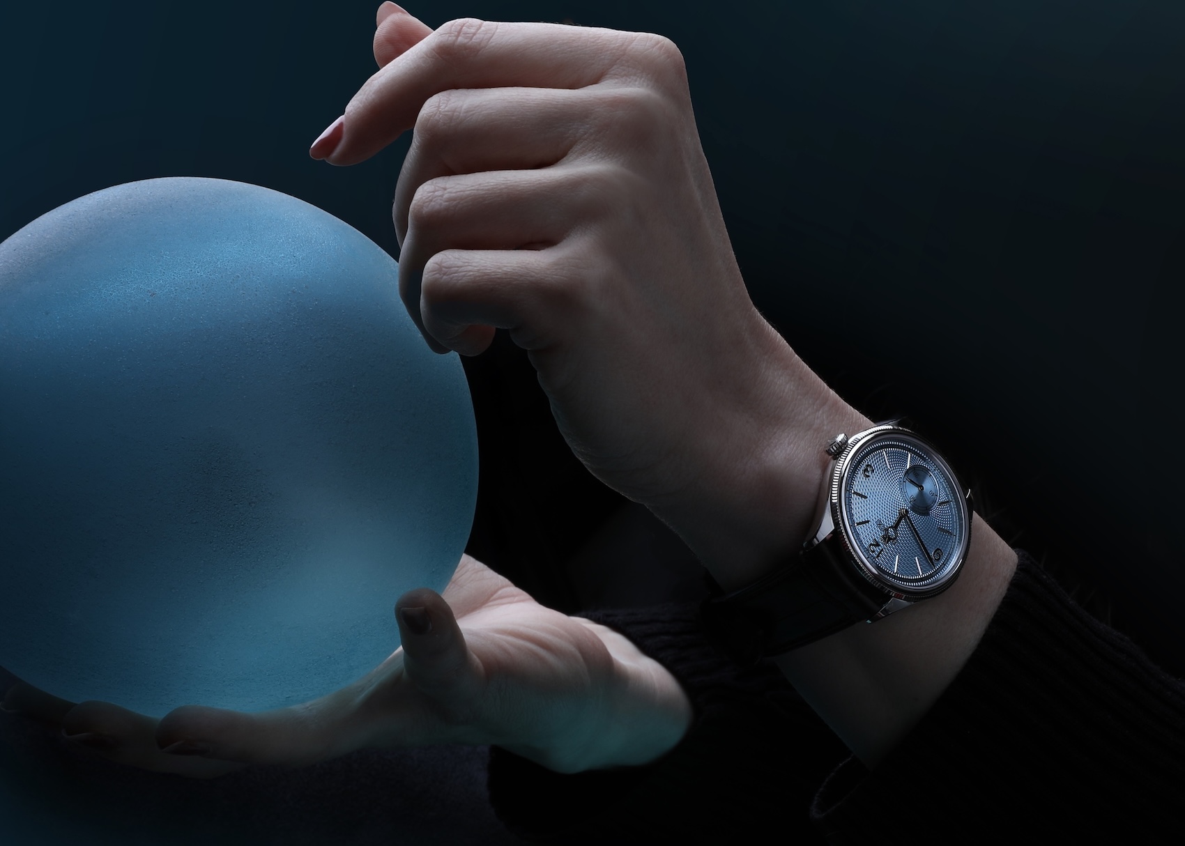 Close up of a platinum Rolex 1908 dress watch with an ice blue guilloche dial worn on a black leather strap.