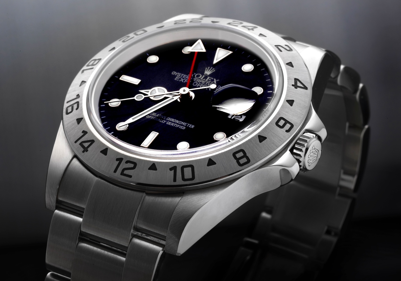 A close-up shot of a neo-vintage Rolex Explorer II Reference 16570 featuring a black dial and brushed steel 24-hour bezel.