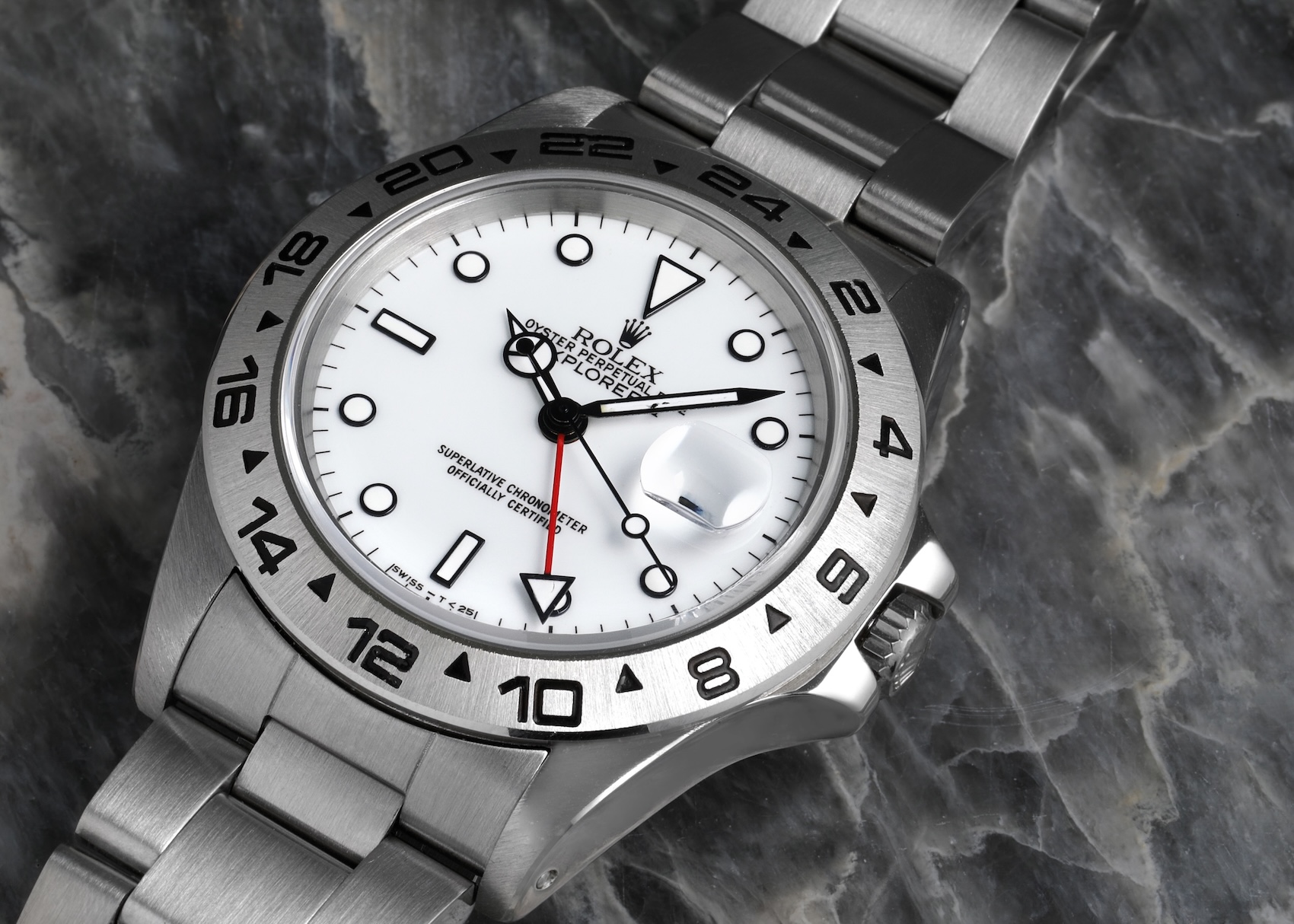 A detailed view of the Rolex Explorer II Reference 16570 showcasing the crisp Polar white dial, black-surround hour markers, and red GMT hand.