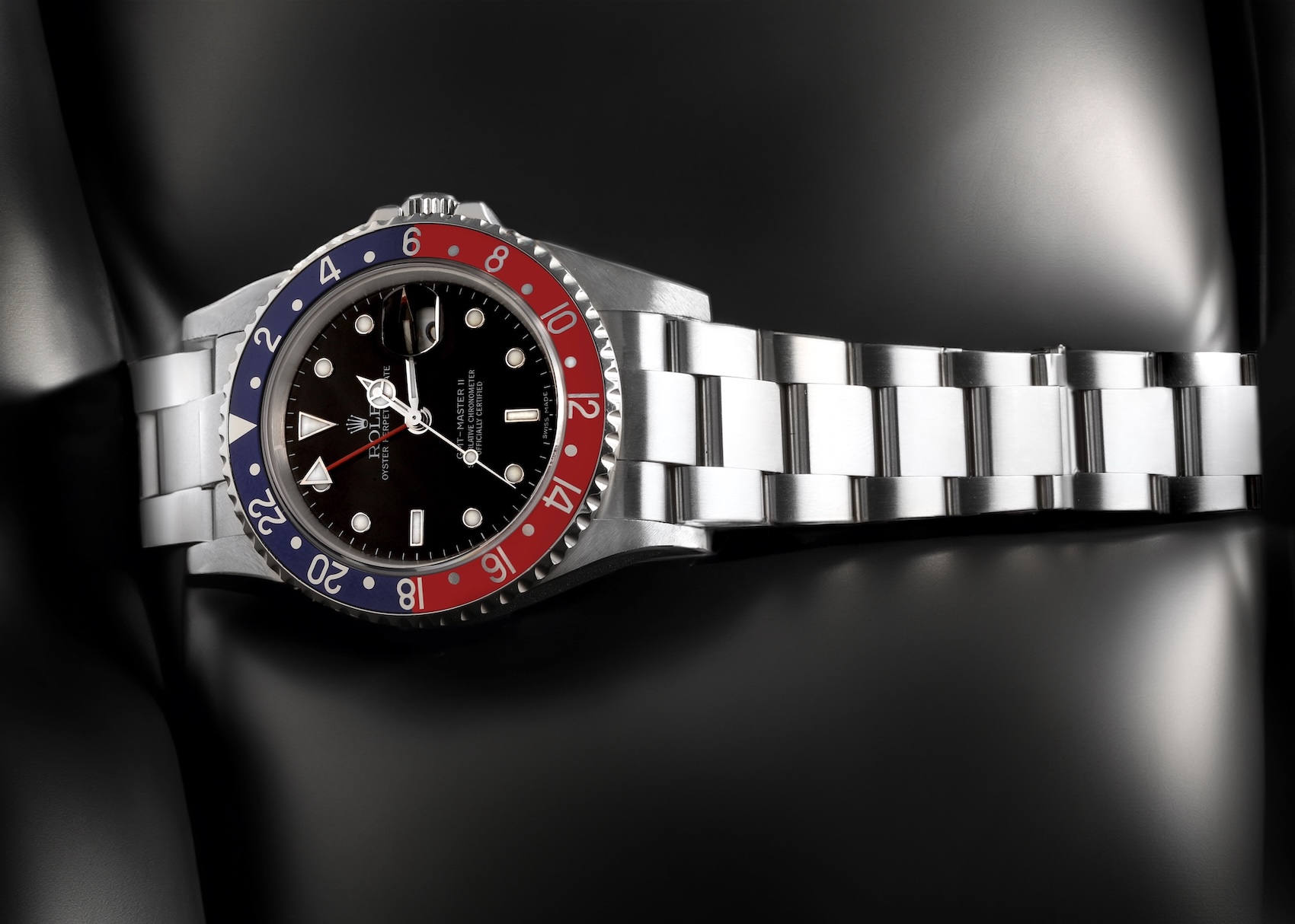 Rolex GMT-Master II Reference 16710 laying flat, showing off a faded red and blue aluminum Pepsi bezel and an error dial.