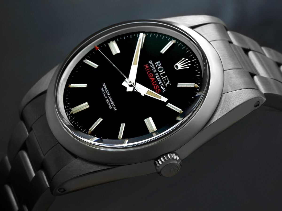 Close up of a vintage Rolex Milgauss reference 1019 featuring a black dial, straight hands, and the signature red arrowhead seconds hand.
