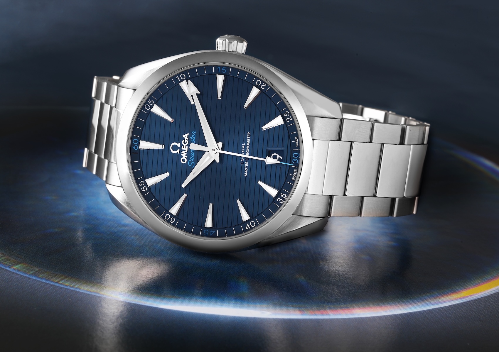Omega Seamaster Aqua Terra 150m featuring a blue horizontal teak dial and stainless steel bracelet.