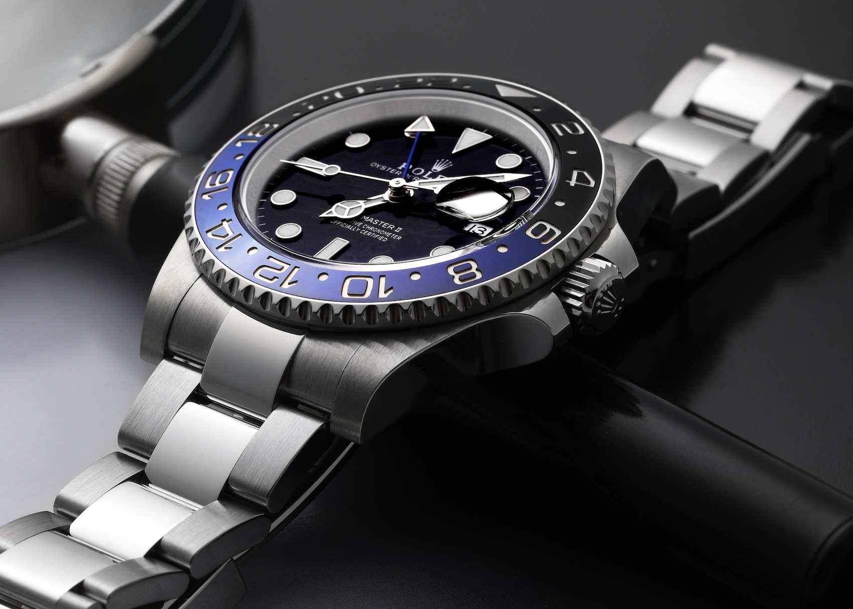 Macro close-up profile view of the Rolex GMT-Master II Batman reference 126710 with a black and blue ceramic bezel on an Oyster bracelet.