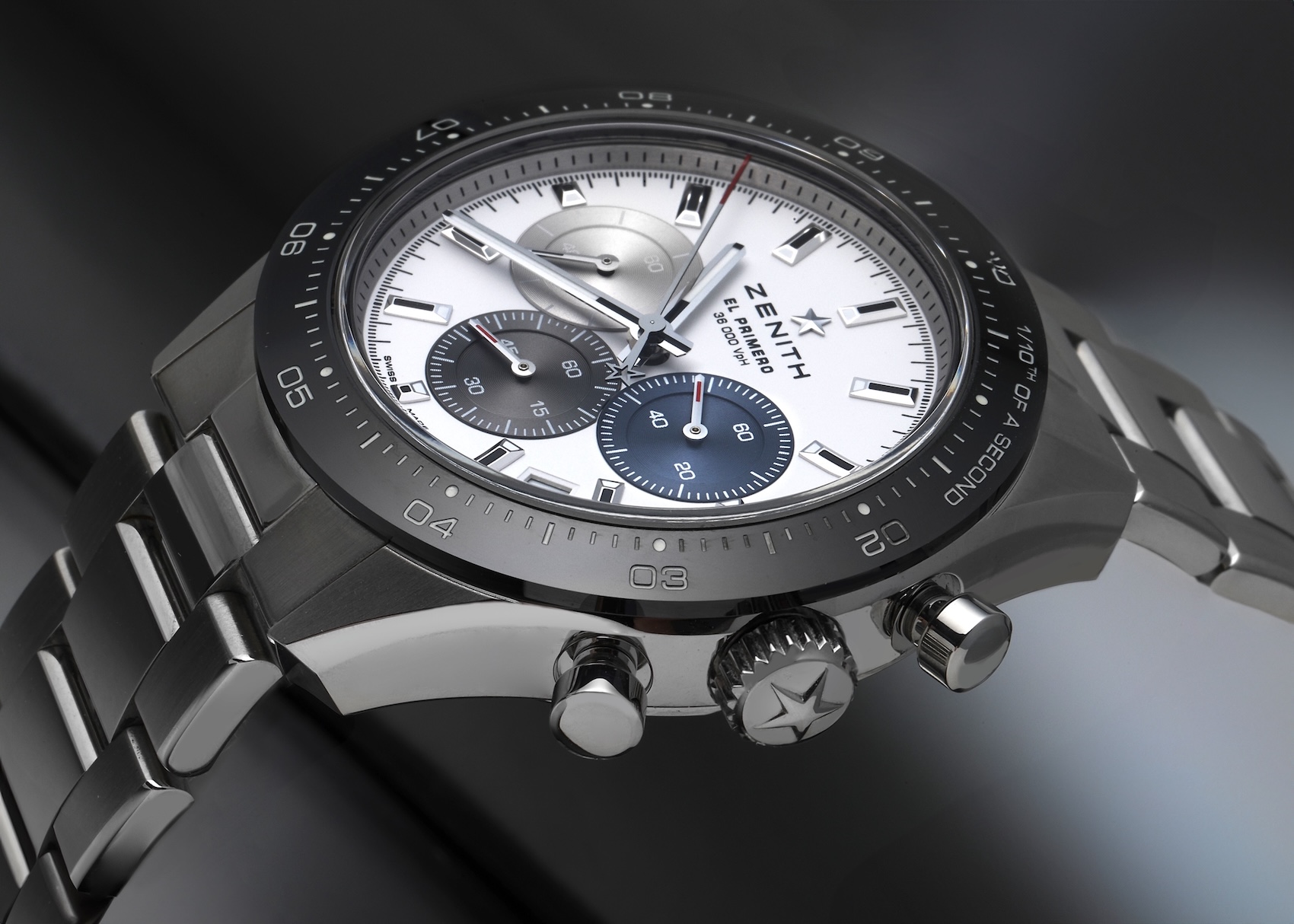 Angled close-up of the core Zenith Chronomaster Sport in stainless steel, highlighting the 1/10th of a second black ceramic bezel, pump pushers, and white dial.