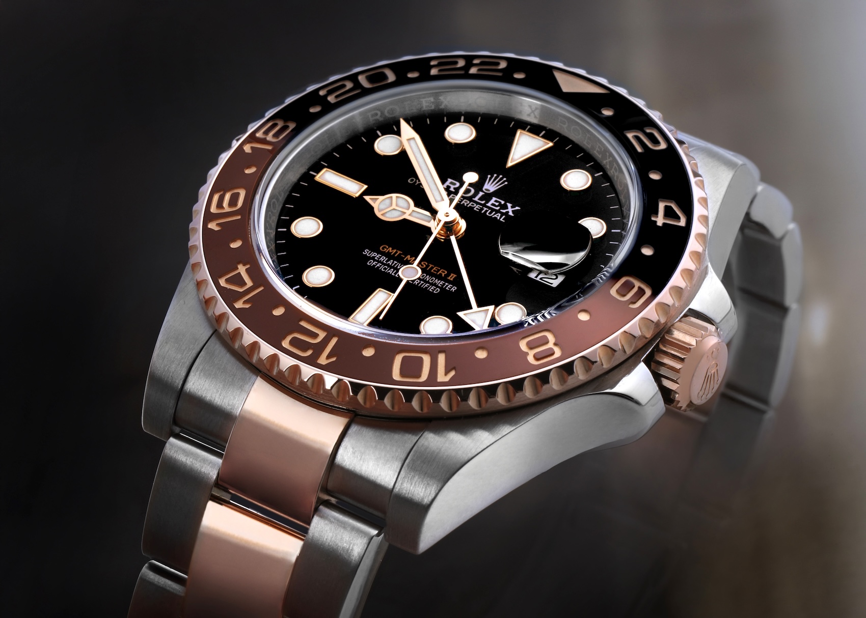 Macro detail shot of the black and brown Cerachrom ceramic bezel and Everose gold crown on a Rolex GMT-Master II 126711CHNR.