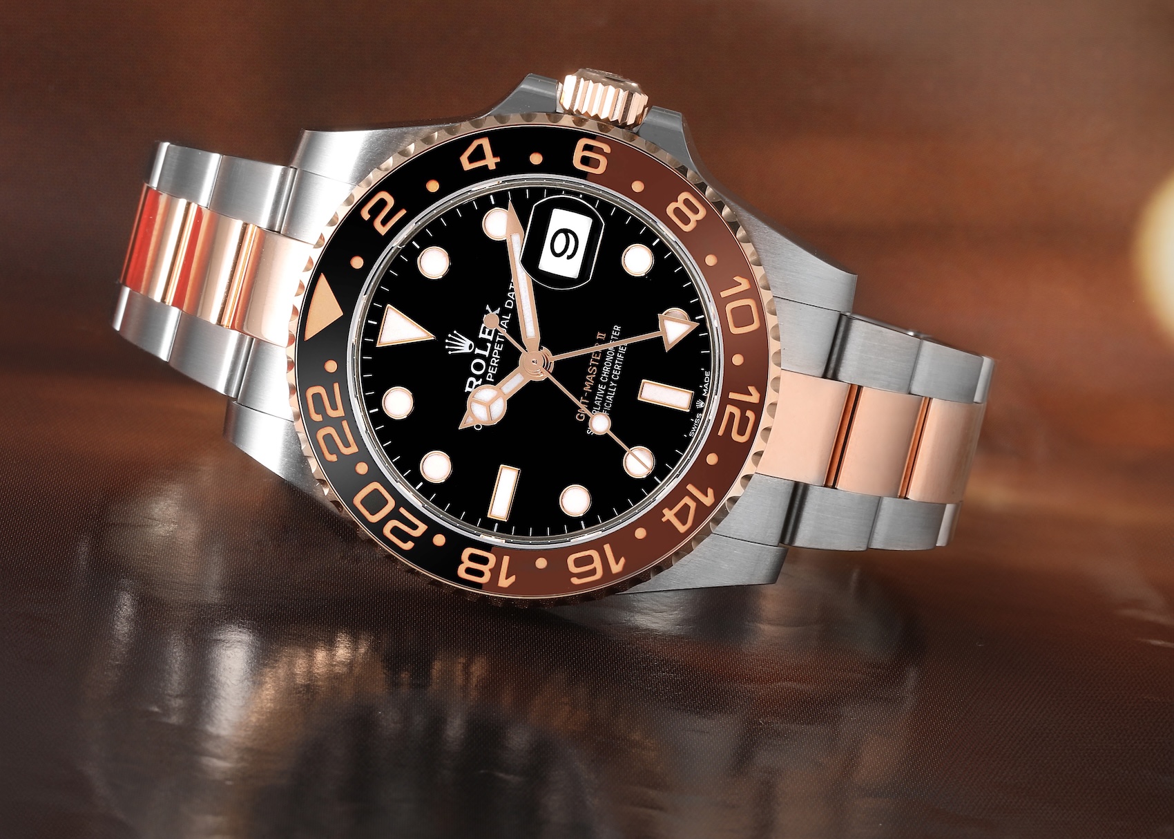 Front view of a two-tone Rolex GMT-Master II 126711CHNR in steel and 18k Everose gold featuring a black and brown ceramic bezel on an Oyster bracelet.