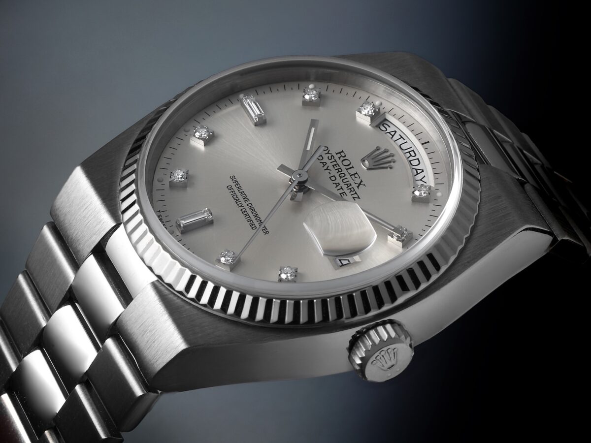 A side profile view of the solid 18k white gold Rolex Oysterquartz 19019, highlighting the angular case design, the fluted bezel, the Rolex crown, and the distinct integrated President-style bracelet links.