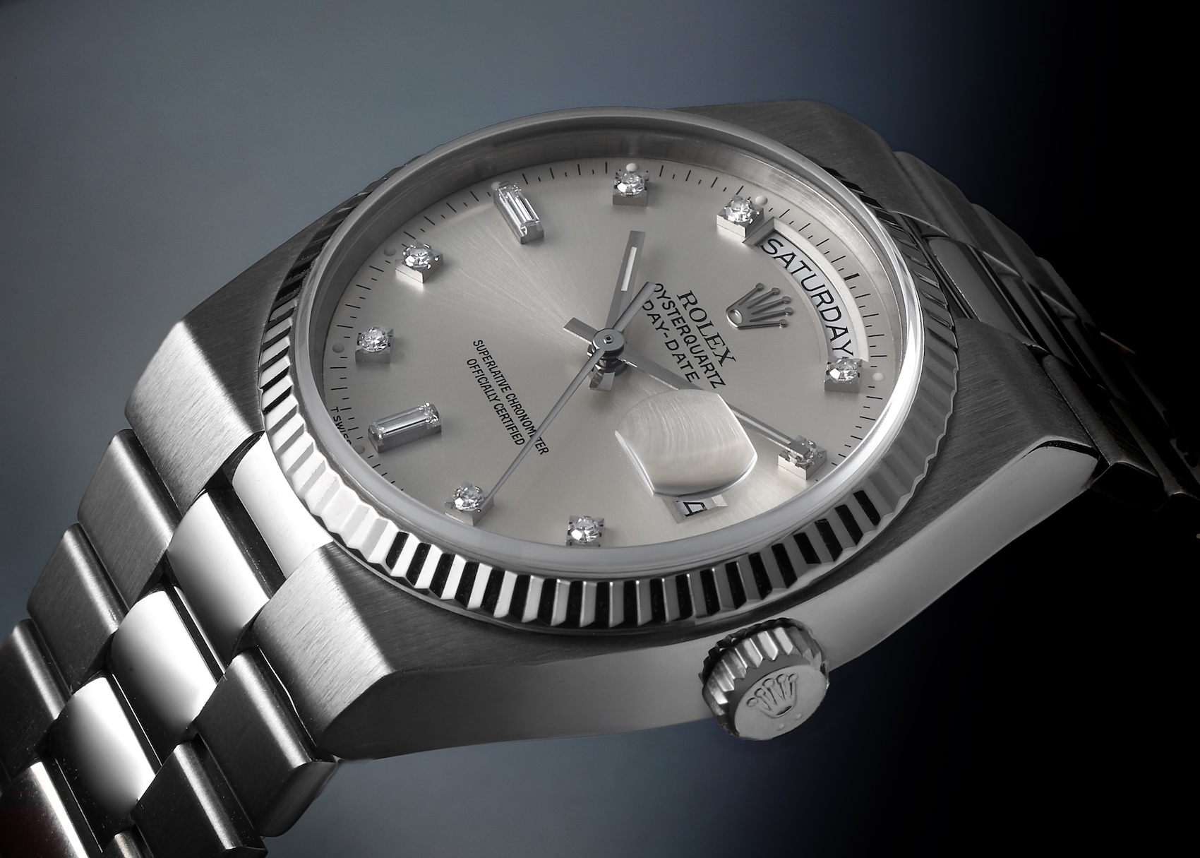A side profile view of the solid 18k white gold Rolex Oysterquartz 19019, highlighting the angular case design, the fluted bezel, the Rolex crown, and the distinct integrated President-style bracelet links.