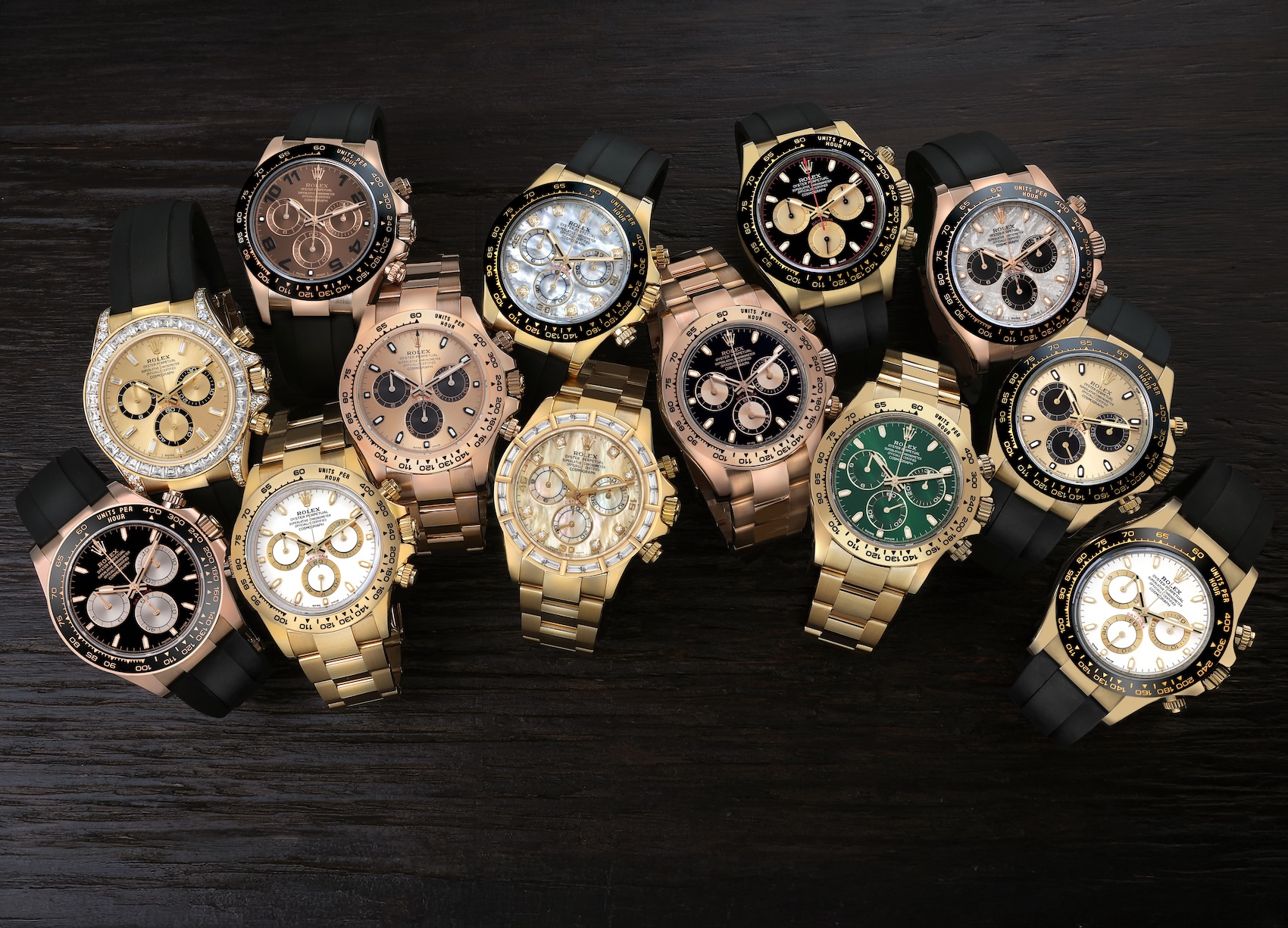 A stunning V-shaped array of authenticated pre-owned Rolex Cosmograph Daytona watches showcasing rare mother-of-pearl, green, and blue dials in stock at SwissWatchExpo in Atlanta.
