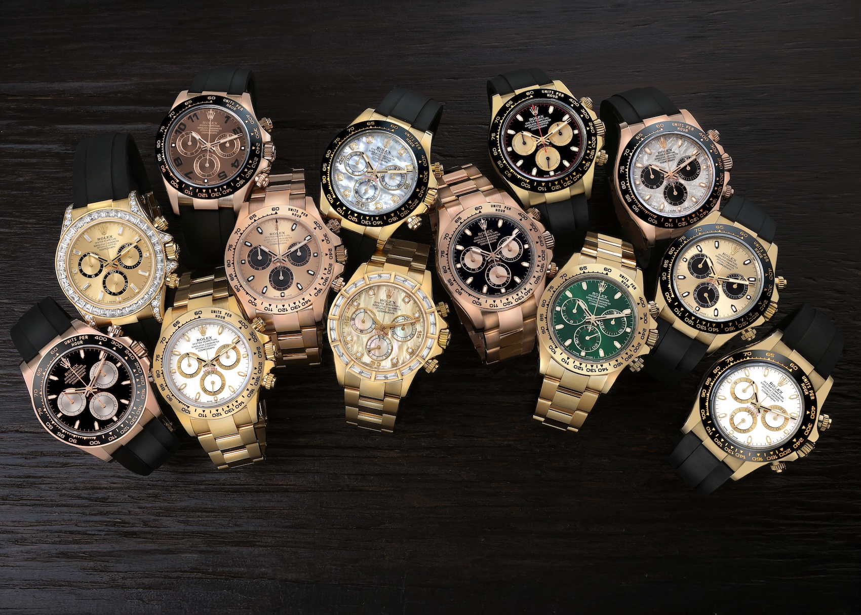 A high-contrast collection of luxury gold Rolex Daytona chronographs on black Oysterflex bracelets, featuring various dials.