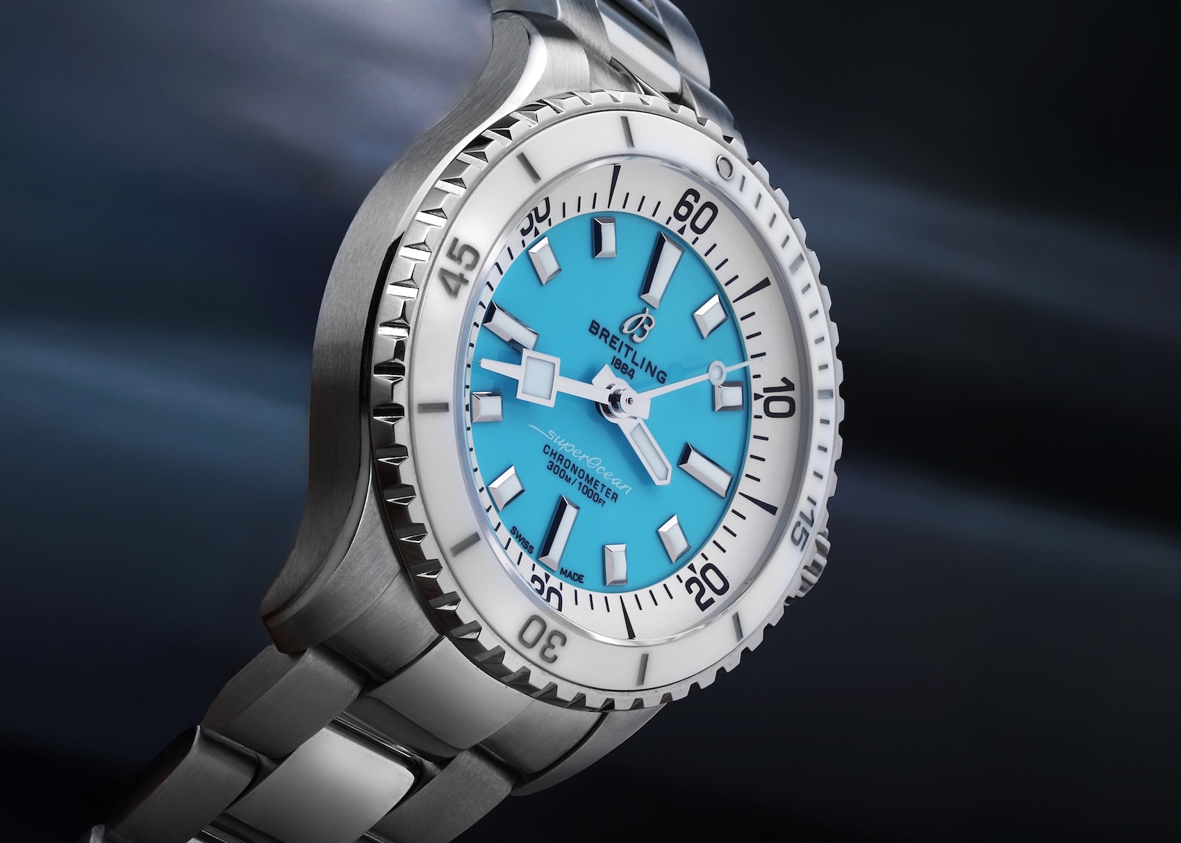 Breitling Superocean 36 watch featuring a vivid turquoise dial and white ceramic bezel on a stainless steel bracelet.