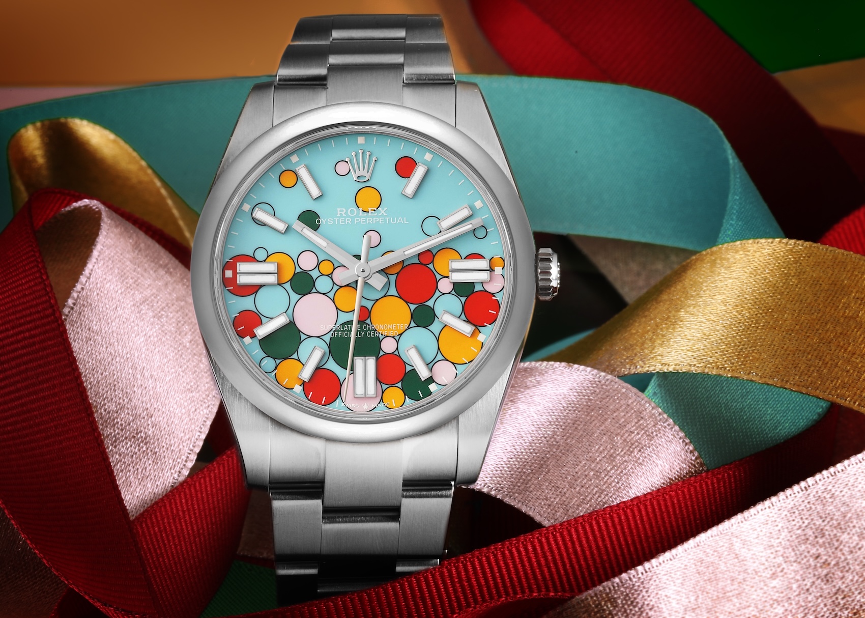 Rolex Oyster Perpetual 41 watch featuring the colorful Celebration motif dial with multi-colored bubbles against a turquoise background.