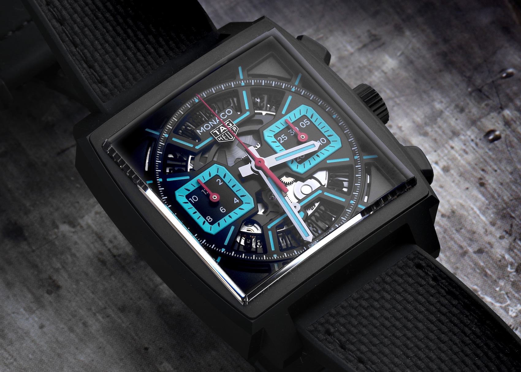 Skeletonized Tag Heuer Monaco Calibre 02 watch in black titanium featuring striking turquoise accents on the sub-dials and hands.