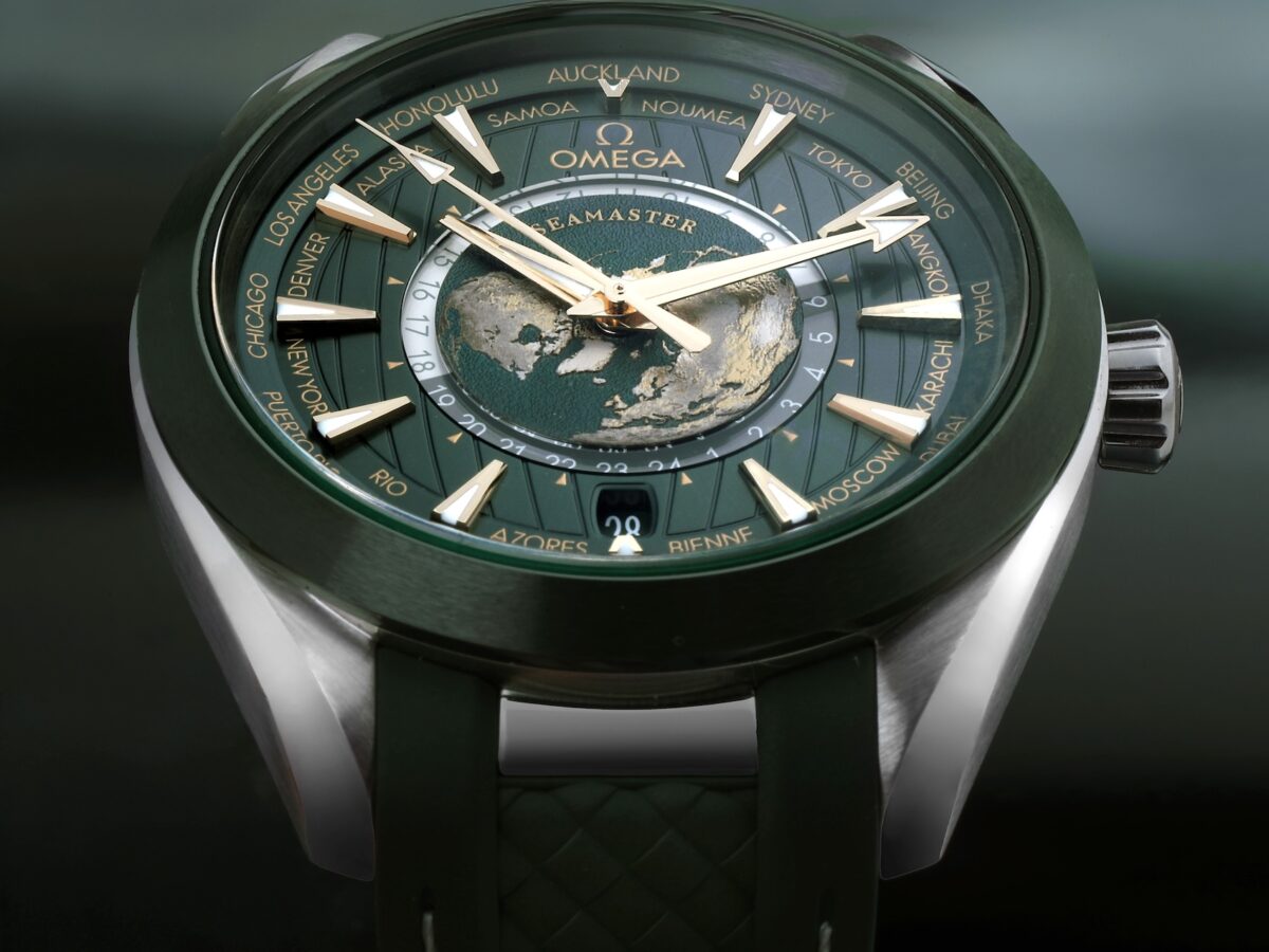Close-up of the green dial on the Omega Seamaster Aqua Terra Worldtimer watch featuring a laser-ablated titanium topographical map of the Earth.