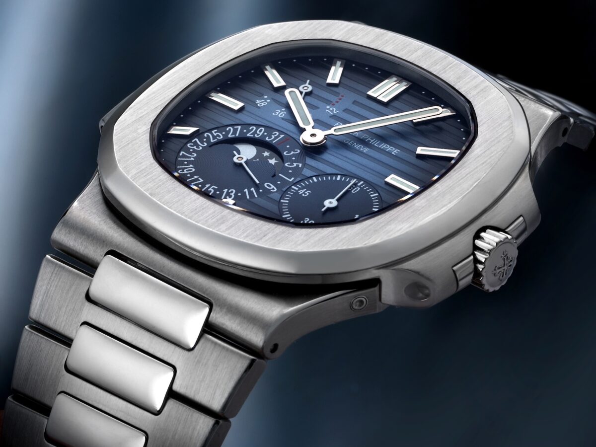 Close-up angled shot of the Patek Philippe Nautilus 5712/1A in stainless steel showcasing the moonphase and blue gradient dial.